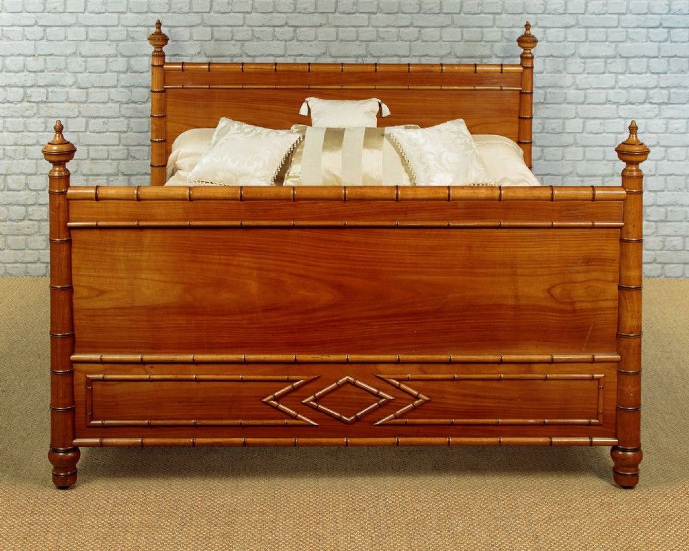 A late 19th-century faux bamboo double bed frame in warm brown wood, featuring turned bamboo-effect posts, finials, and panelled headboard and footboard. View II