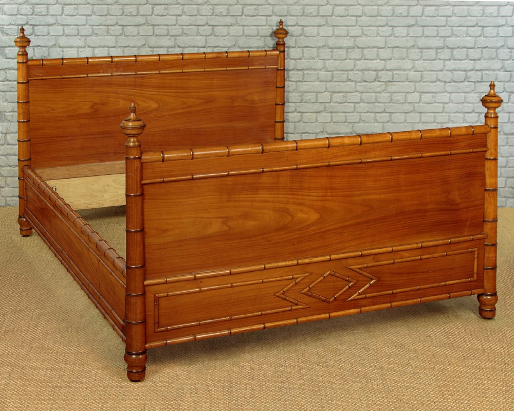 A late 19th-century faux bamboo double bed frame in warm brown wood, featuring turned bamboo-effect posts, finials, and panelled headboard and footboard. View III