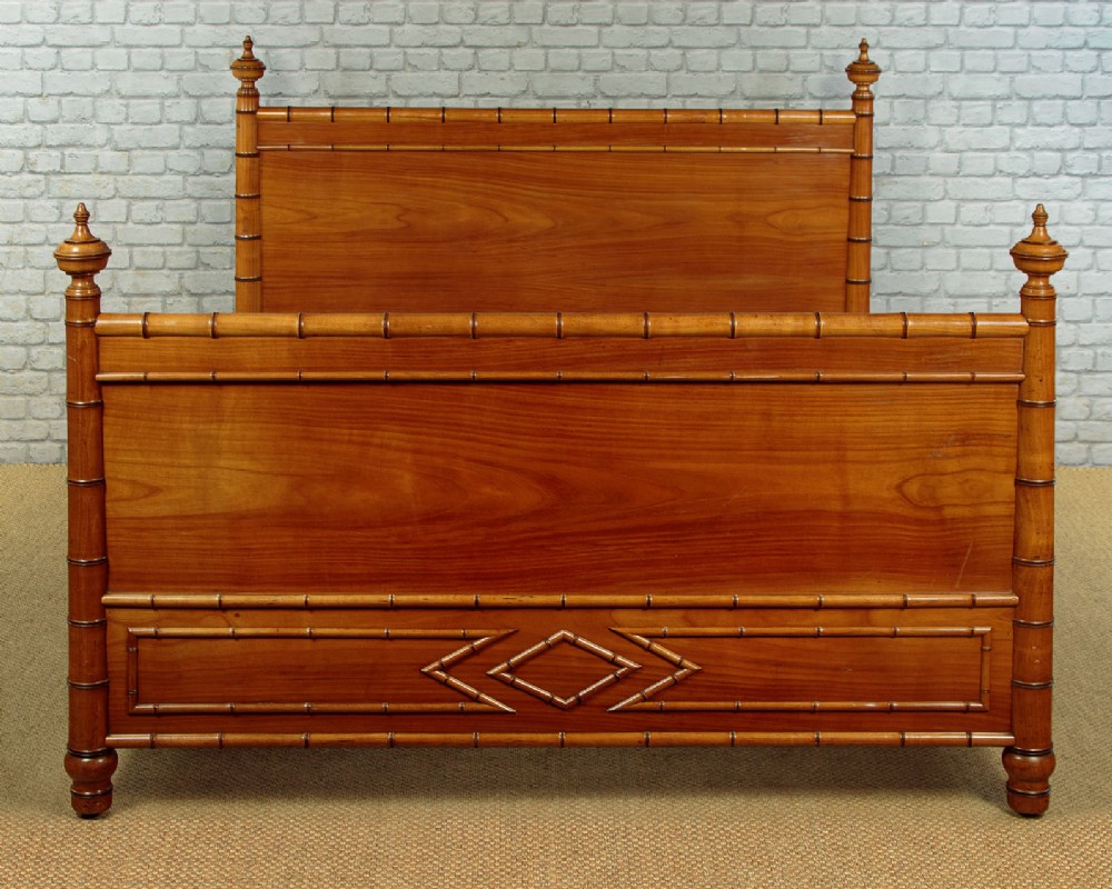 A late 19th-century faux bamboo double bed frame in warm brown wood, featuring turned bamboo-effect posts, finials, and panelled headboard and footboard. View IV