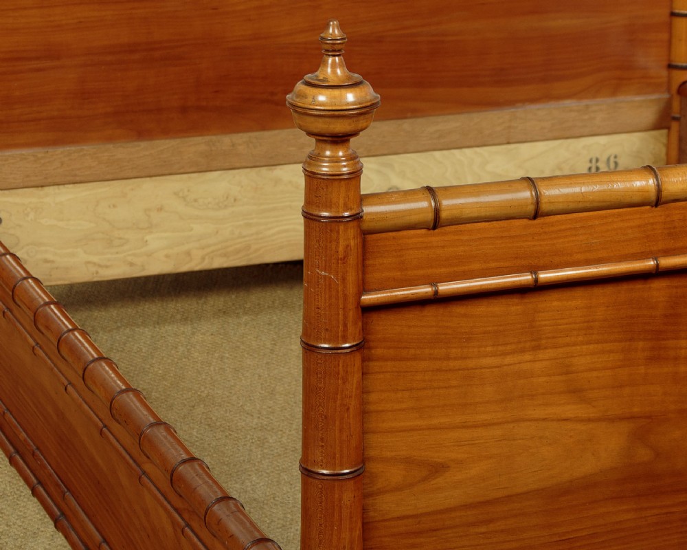 A late 19th-century faux bamboo double bed frame in warm brown wood, featuring turned bamboo-effect posts, finials, and panelled headboard and footboard. View V