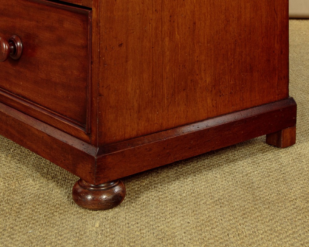 A nineteenth-century mahogany linen press featuring flame mahogany panel doors opening to reveal timber trays above a base of four drawers with turned wooden knobs. View XIII