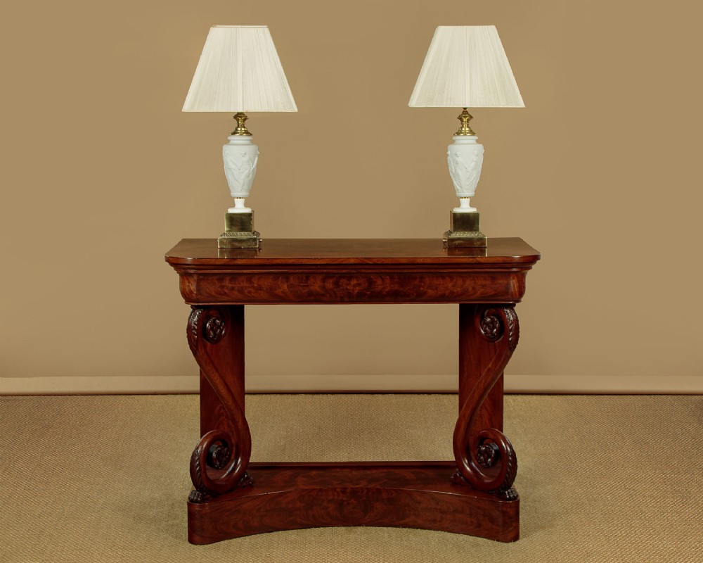 A 19th-century Victorian mahogany console table featuring carved S-scroll front supports and a concave plinth base. View II