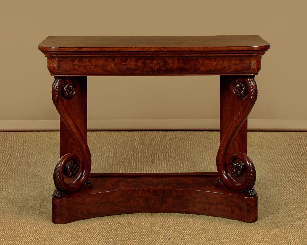 A 19th-century Victorian mahogany console table featuring carved S-scroll front supports and a concave plinth base. View III