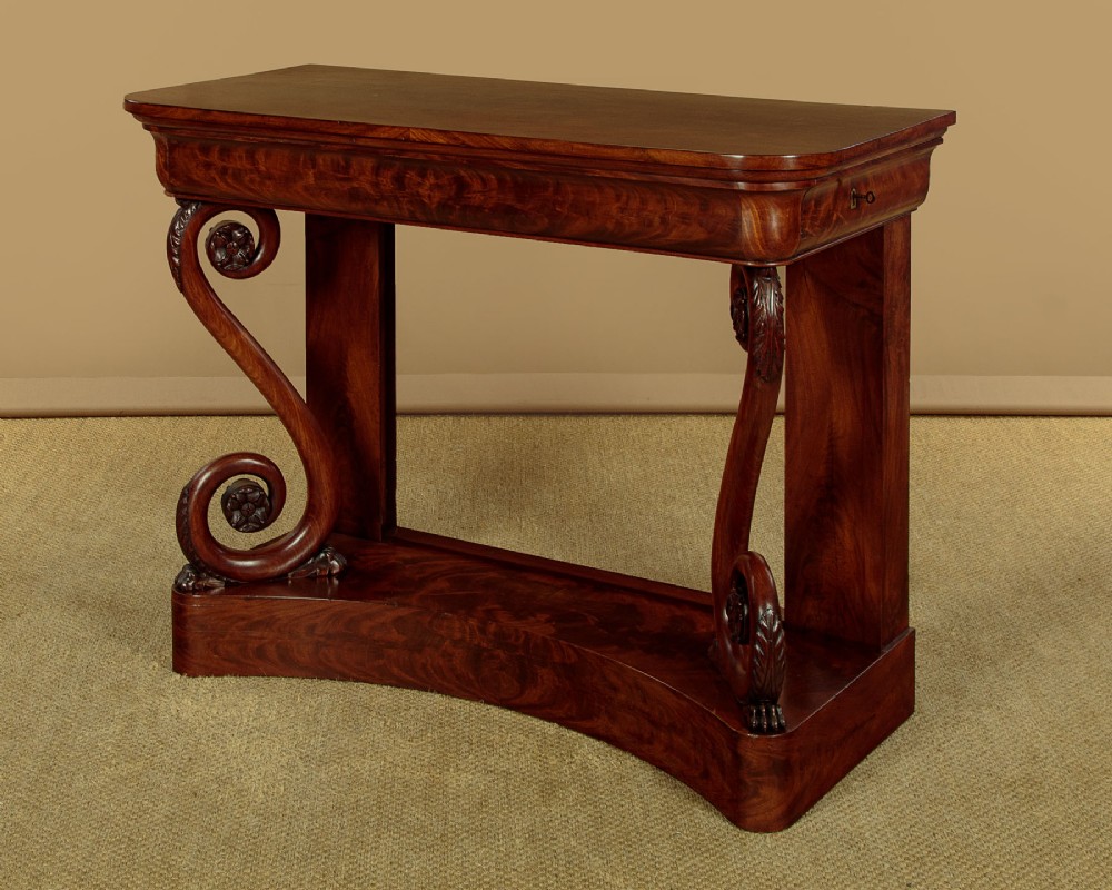 A 19th-century Victorian mahogany console table featuring carved S-scroll front supports and a concave plinth base. View IV