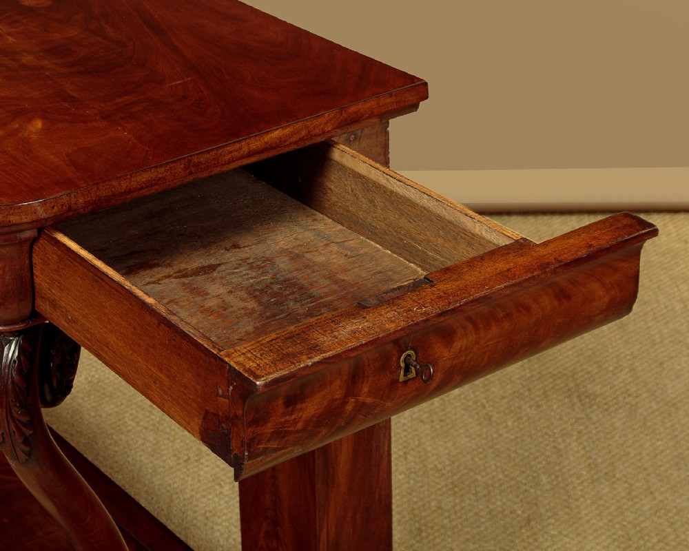 A 19th-century Victorian mahogany console table featuring carved S-scroll front supports and a concave plinth base. View VIII