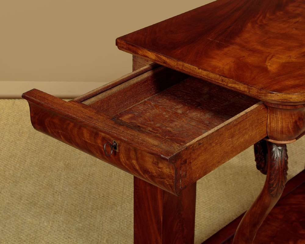 A 19th-century Victorian mahogany console table featuring carved S-scroll front supports and a concave plinth base. View IX