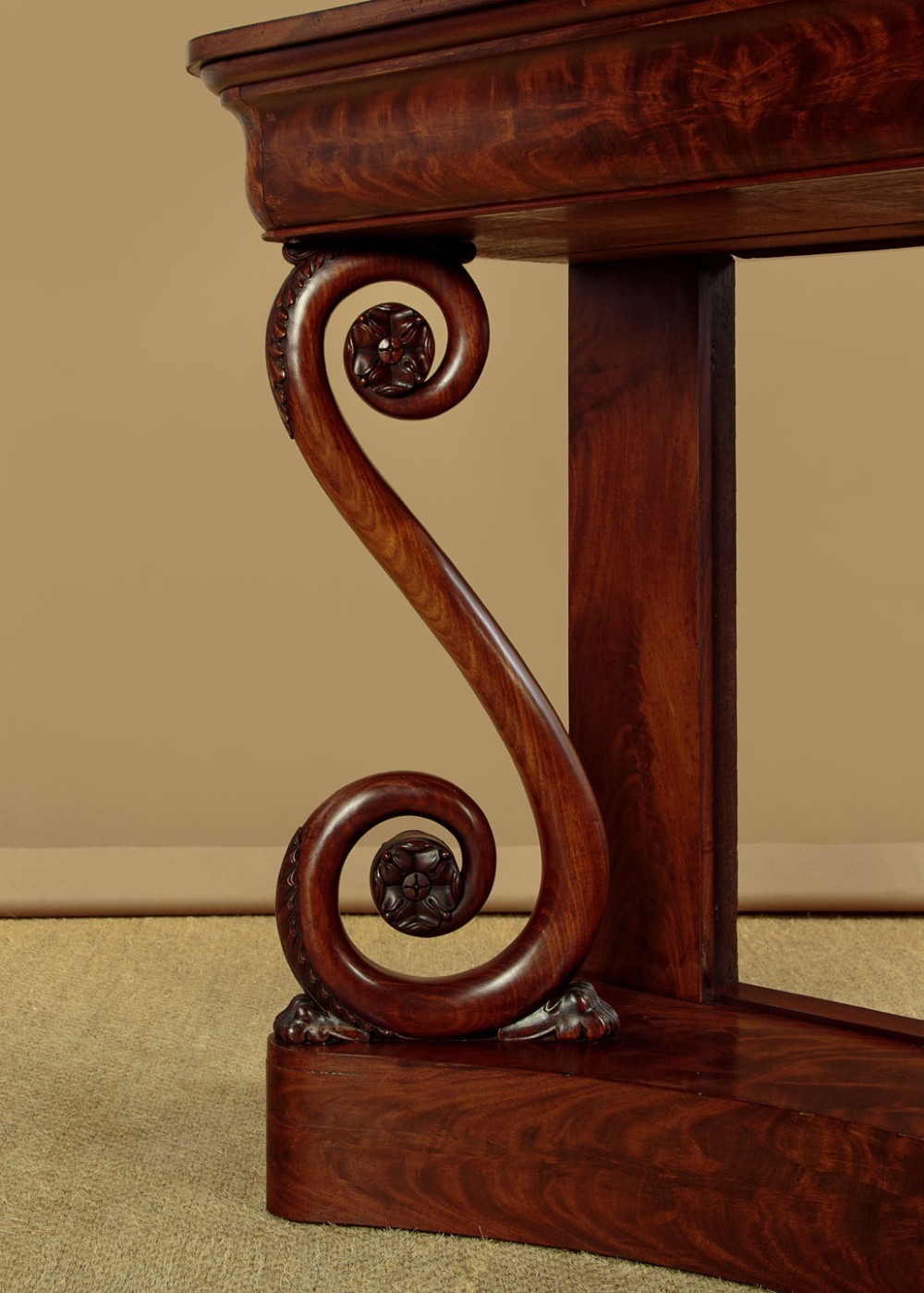 A 19th-century Victorian mahogany console table featuring carved S-scroll front supports and a concave plinth base. View X