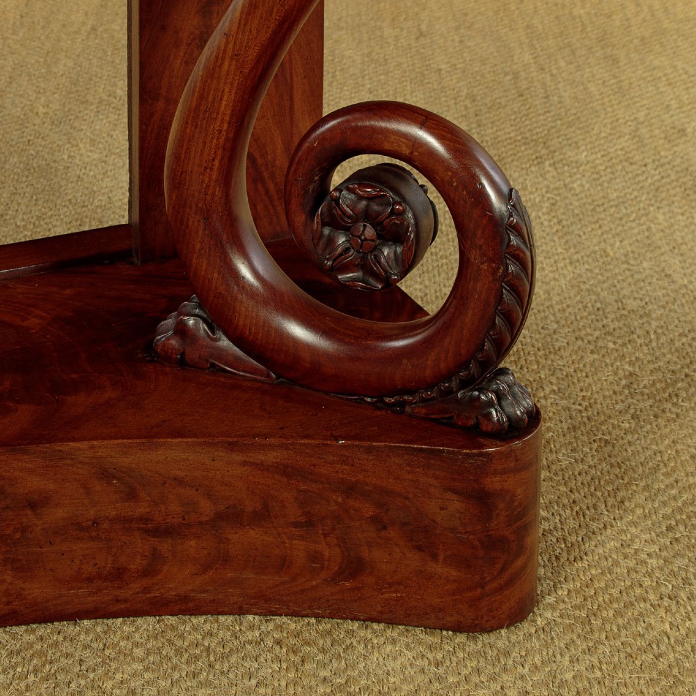 A 19th-century Victorian mahogany console table featuring carved S-scroll front supports and a concave plinth base. View XII