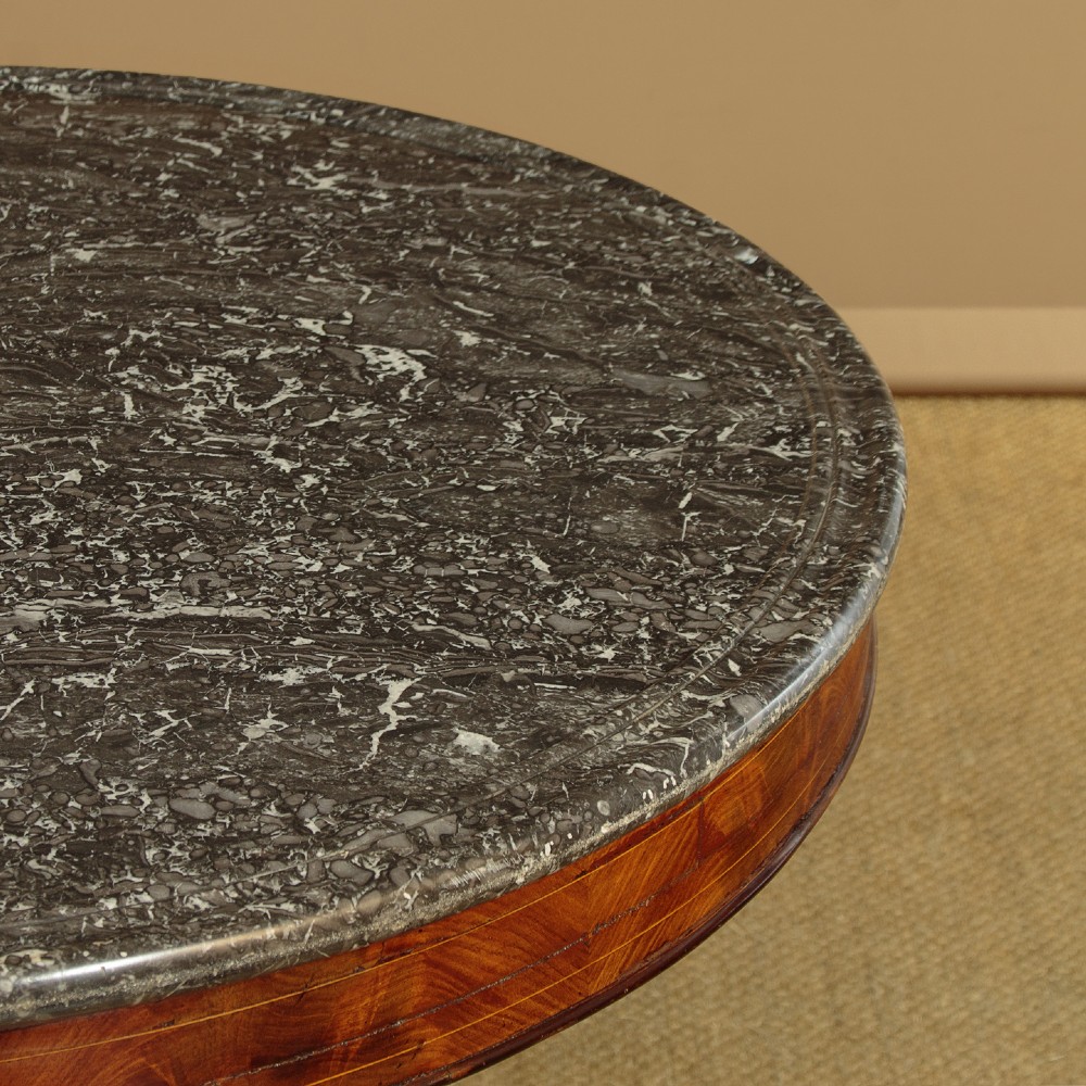 A 19th-century circular gueridon centre table featuring a dark grey marble top, warm walnut veneer with string inlay, a bulbous pedestal, and carved paw feet. View V