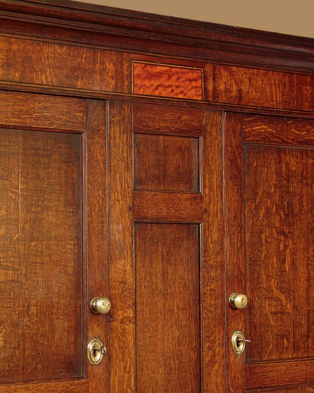 A nineteenth-century Welsh oak tack cupboard featuring a fielded twin-panel door upper section set over a chest of seven drawers with brass turned knobs. View VII