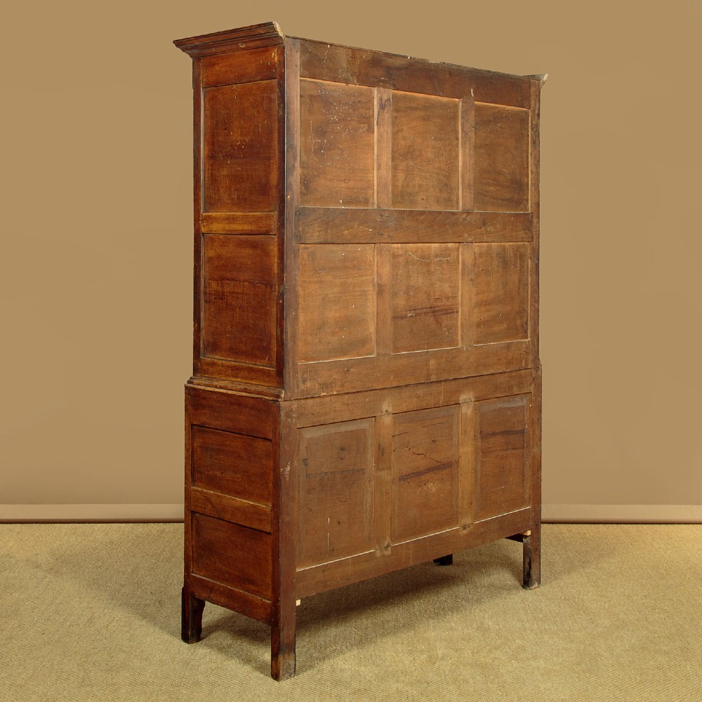 A nineteenth-century Welsh oak tack cupboard featuring a fielded twin-panel door upper section set over a chest of seven drawers with brass turned knobs. View XIV
