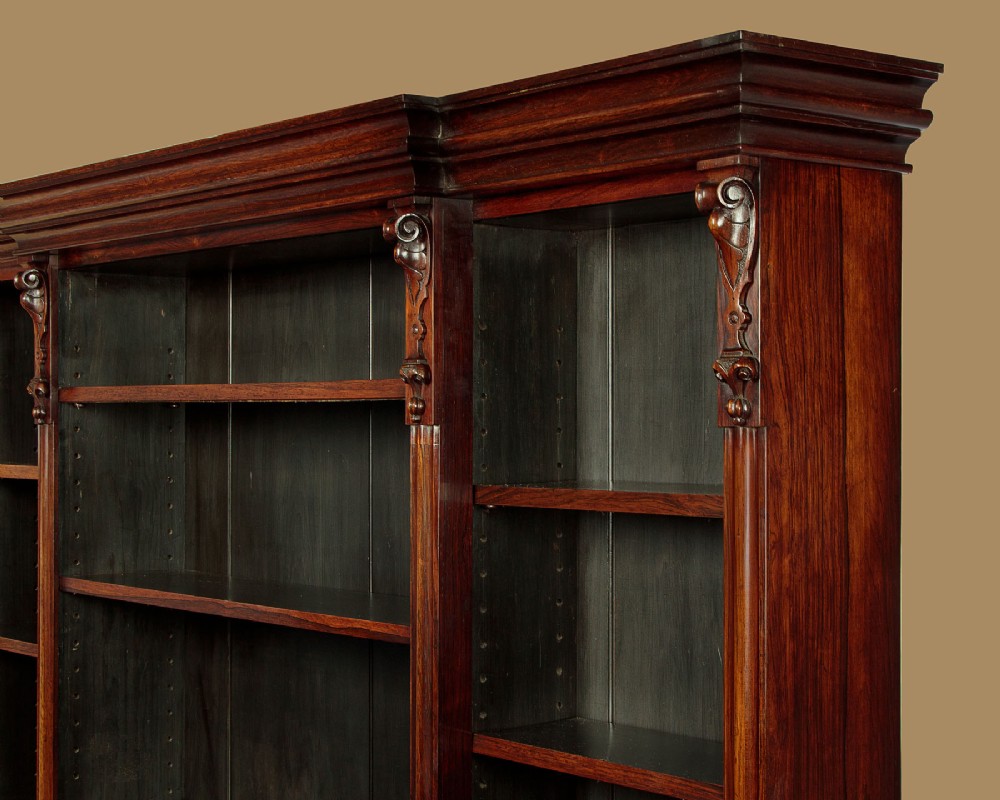 A mid-19th century dark rosewood open breakfront bookcase featuring a central projecting section flanked by narrower side shelves. View V