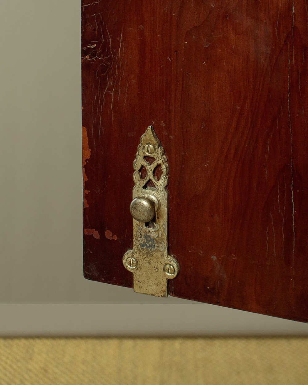 A small veneered brown wood cabinet featuring decorative door pulls, mounted atop a carved silver gilt stand with cabriole legs and a central shell motif. View IX
