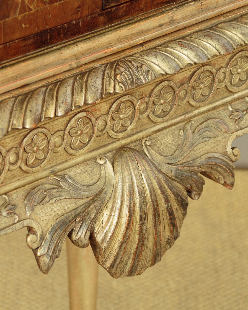 A small veneered brown wood cabinet featuring decorative door pulls, mounted atop a carved silver gilt stand with cabriole legs and a central shell motif. View XI