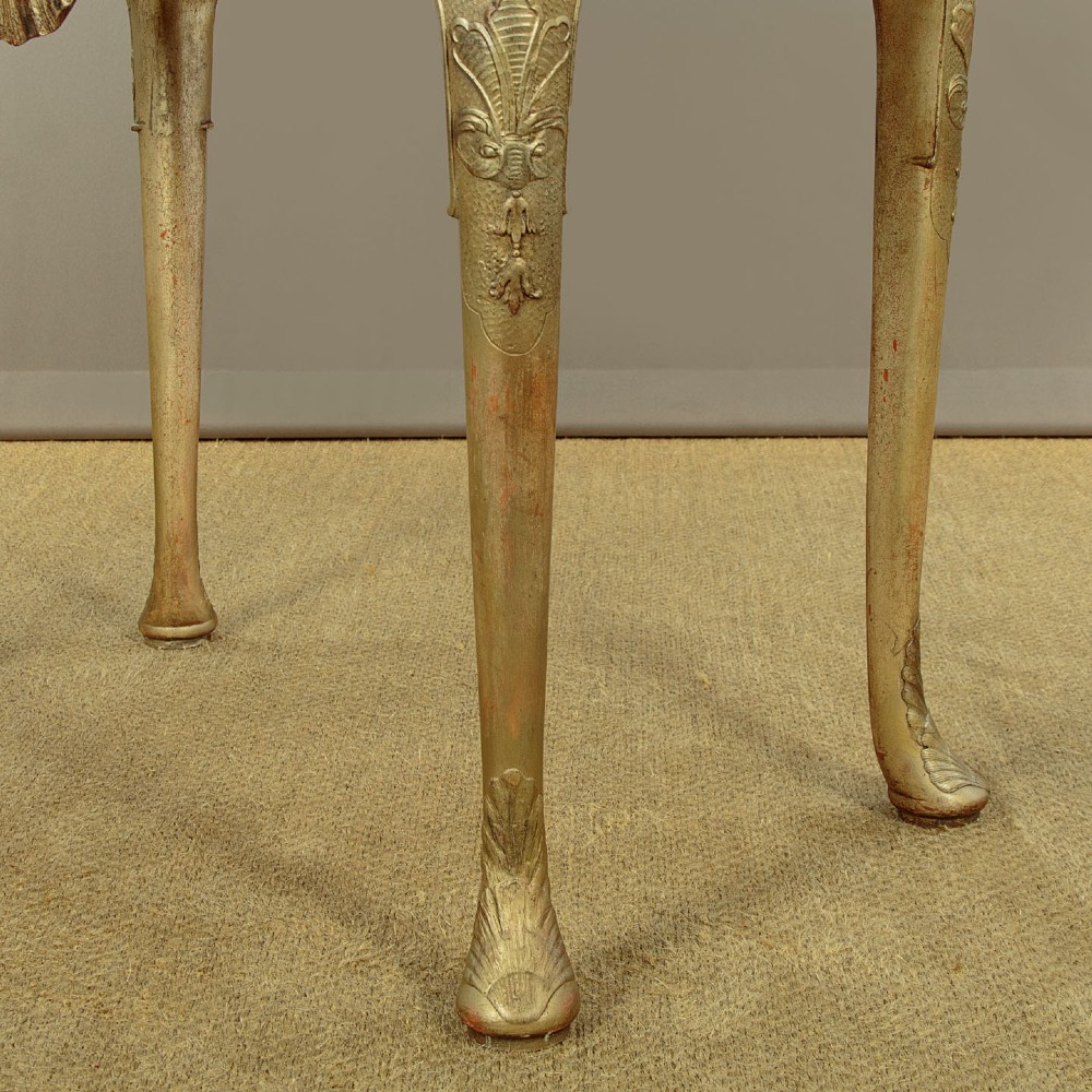 A small veneered brown wood cabinet featuring decorative door pulls, mounted atop a carved silver gilt stand with cabriole legs and a central shell motif. View XIII