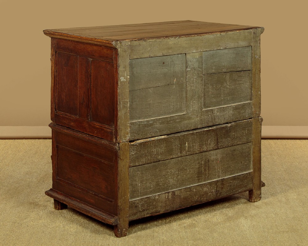 A Charles II solid oak chest of drawers featuring geometric panelled drawer fronts and brass teardrop handles. View XII