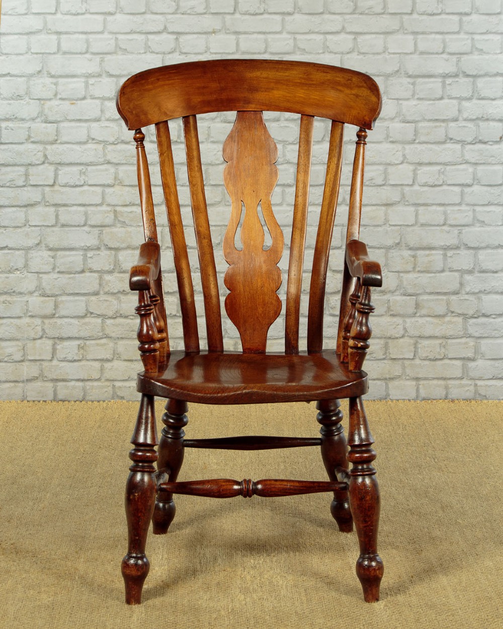 A Victorian highback wooden armchair featuring turned legs, curved armrests, a contoured seat, and a pierced back splat. View II