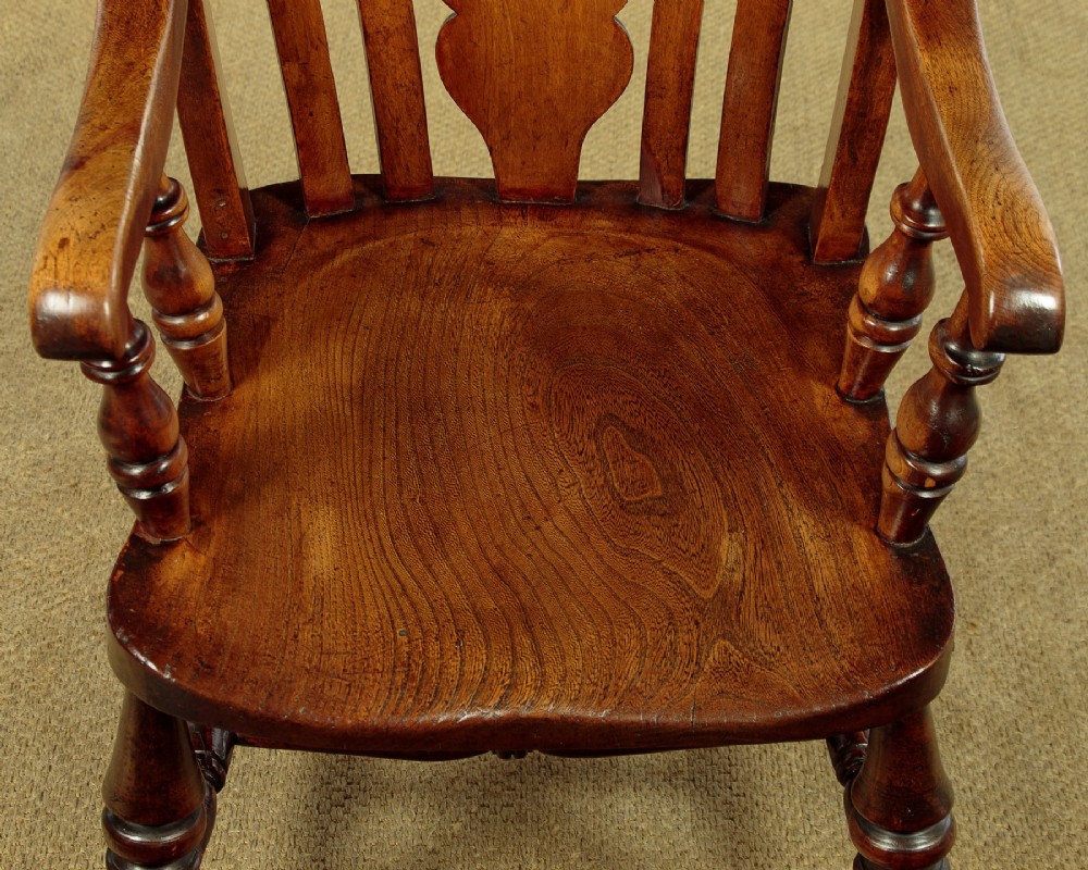 A Victorian highback wooden armchair featuring turned legs, curved armrests, a contoured seat, and a pierced back splat. View VII