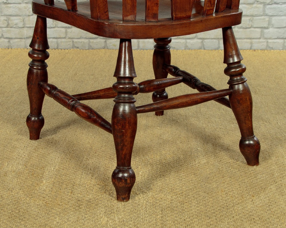 A Victorian highback wooden armchair featuring turned legs, curved armrests, a contoured seat, and a pierced back splat. View XII