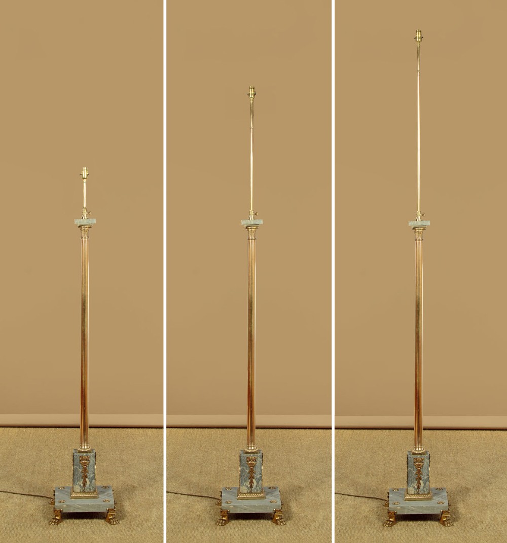 An adjustable French Empire style brass floor lamp featuring a fluted standard column set upon a grey marble base with brass claw feet. View III