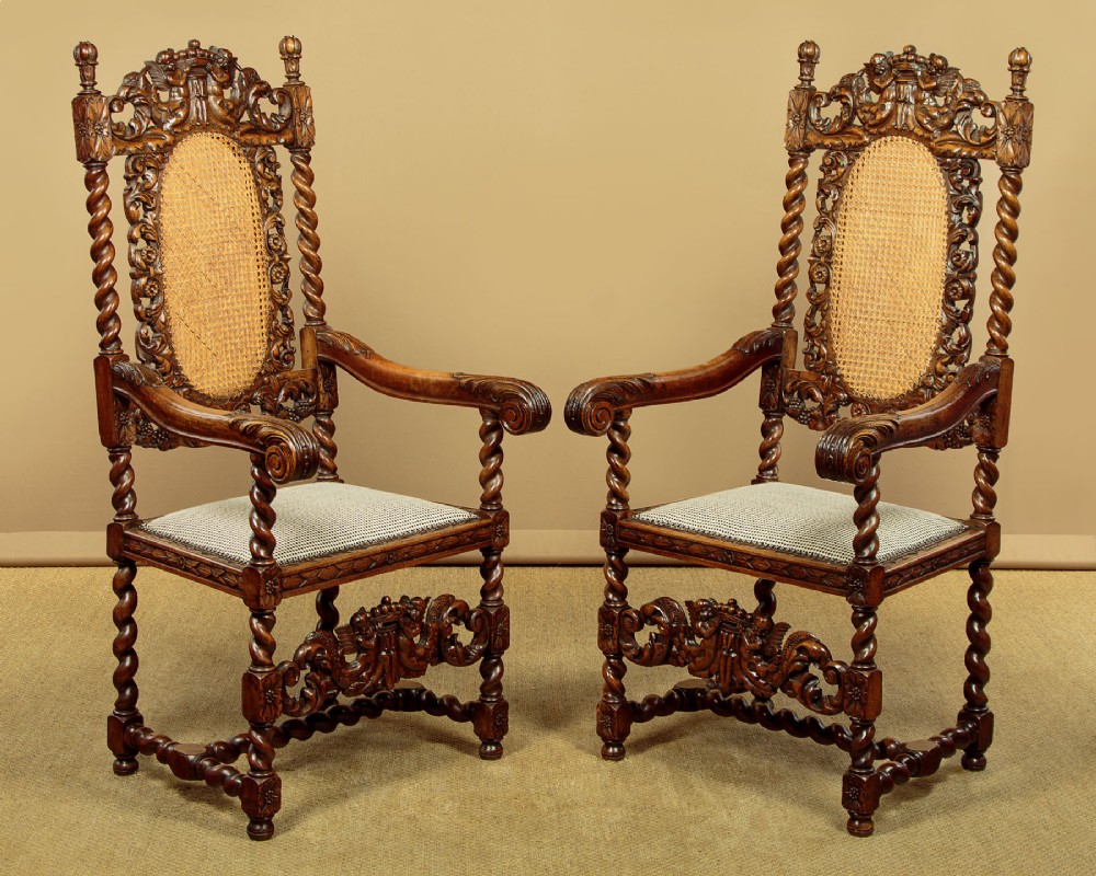 A pair of carved walnut armchairs featuring oval cane back panels, scroll armrests, and barley twist legs. View II