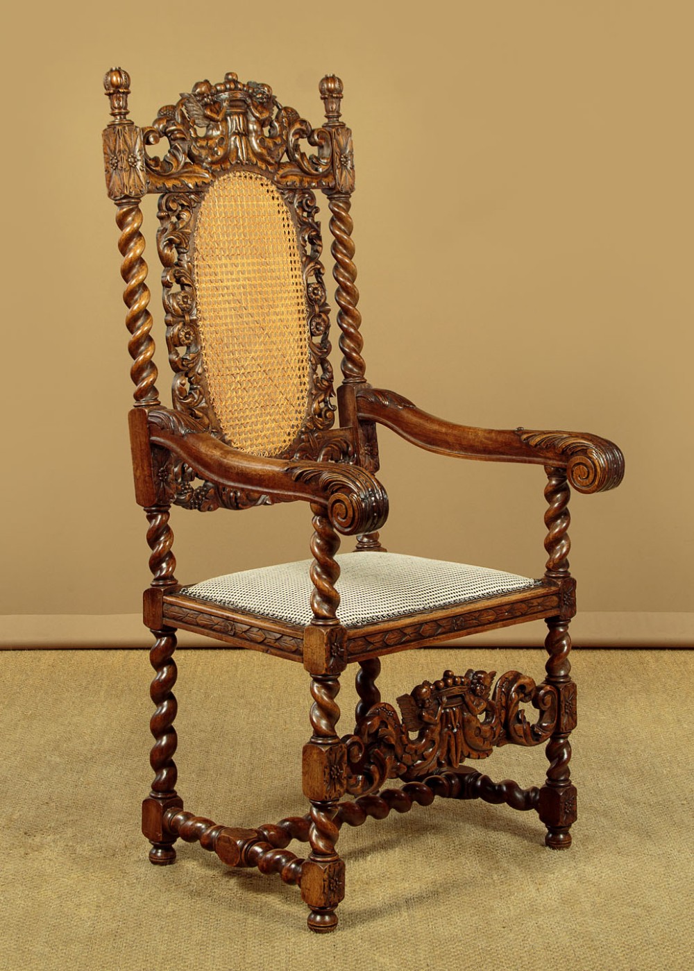 A pair of carved walnut armchairs featuring oval cane back panels, scroll armrests, and barley twist legs. View V