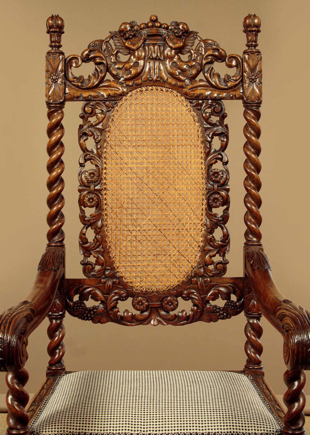 A pair of carved walnut armchairs featuring oval cane back panels, scroll armrests, and barley twist legs. View VI