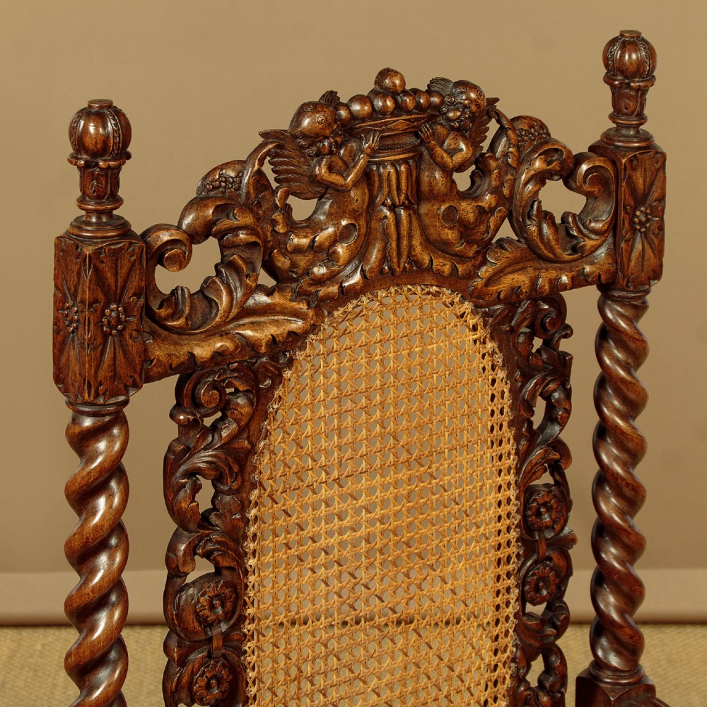 A pair of carved walnut armchairs featuring oval cane back panels, scroll armrests, and barley twist legs. View VII