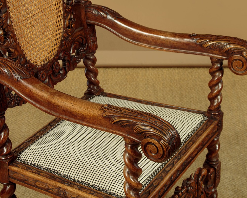 A pair of carved walnut armchairs featuring oval cane back panels, scroll armrests, and barley twist legs. View X