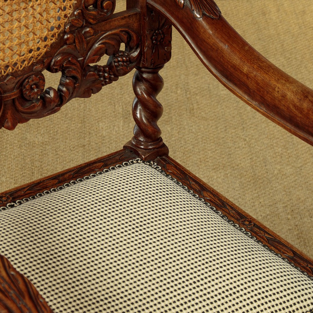 A pair of carved walnut armchairs featuring oval cane back panels, scroll armrests, and barley twist legs. View XII