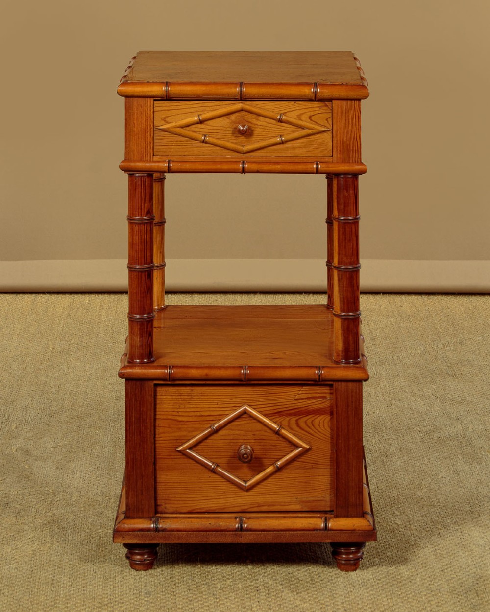 Late 19th-century faux bamboo wooden bedside cabinet featuring turned bamboo-style supports, an upper drawer with diamond moulding, an open shelf, and a lower drawer section. View II
