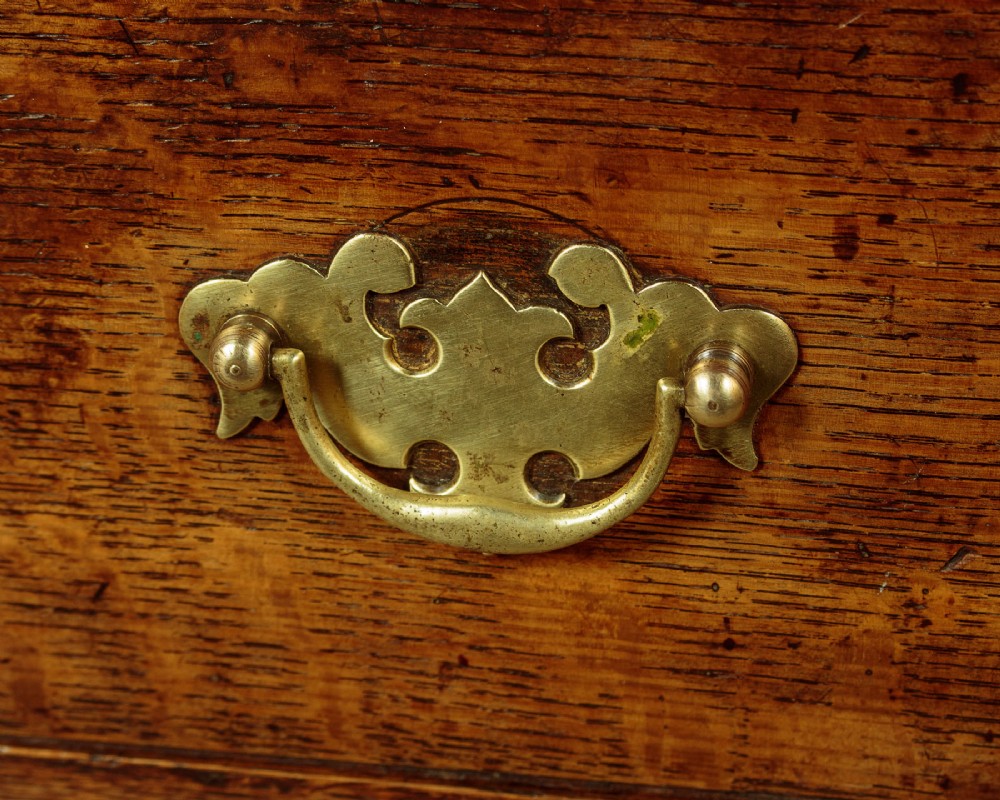 A Georgian oak Welsh dresser base featuring eight drawers with brass handles, a scalloped apron, turned front legs, and an open potboard lower shelf. View IX