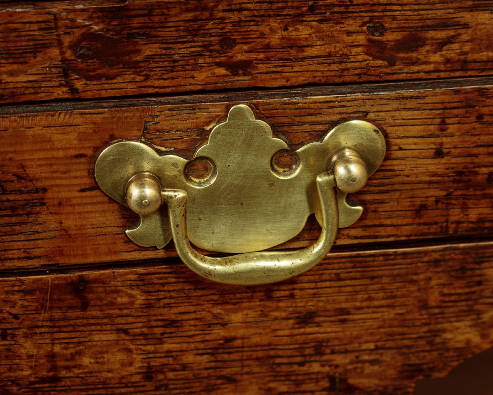 A Georgian oak Welsh dresser base featuring eight drawers with brass handles, a scalloped apron, turned front legs, and an open potboard lower shelf. View X
