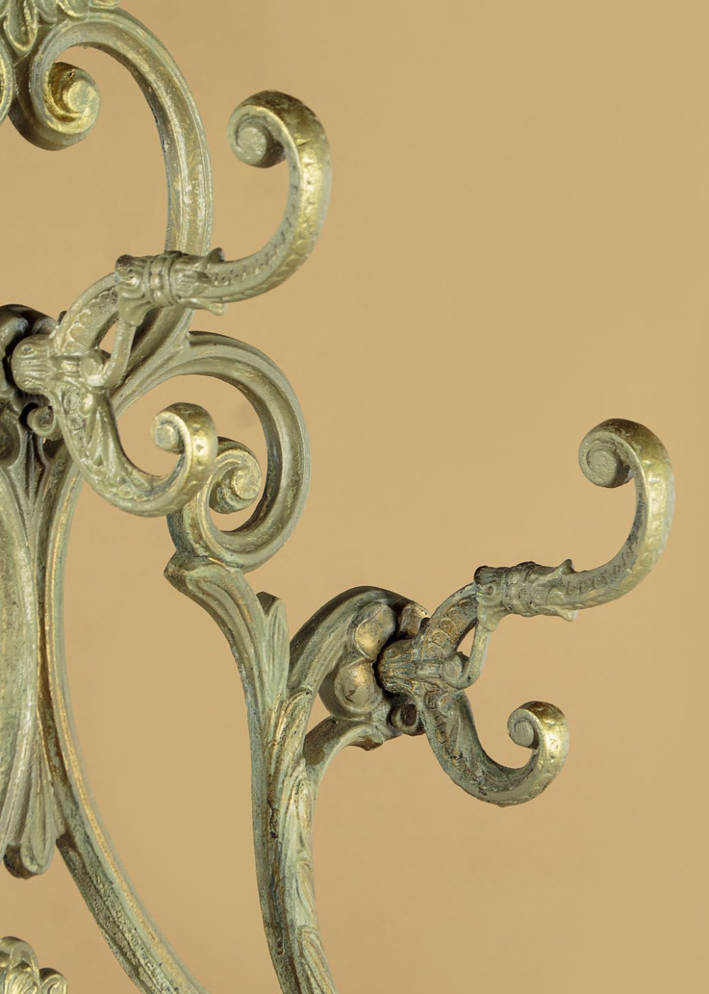 An ornate Victorian painted cast iron hall stand featuring scrollwork motifs, multiple coat hooks, a central oval mirror, and an umbrella drip tray base. View VII