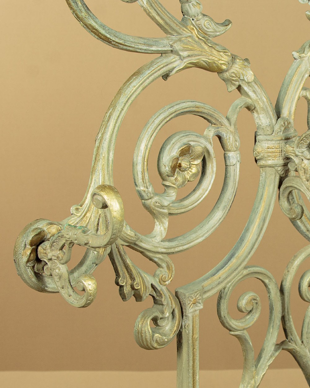 An ornate Victorian painted cast iron hall stand featuring scrollwork motifs, multiple coat hooks, a central oval mirror, and an umbrella drip tray base. View IX