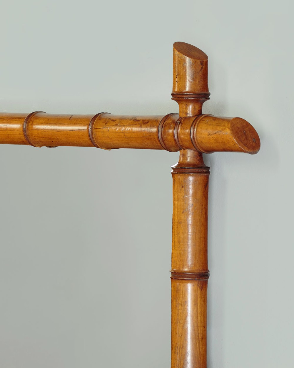 A late nineteenth-century rectangular wall mirror featuring a carved wooden frame that simulates natural bamboo with overlapping corner joints. View V