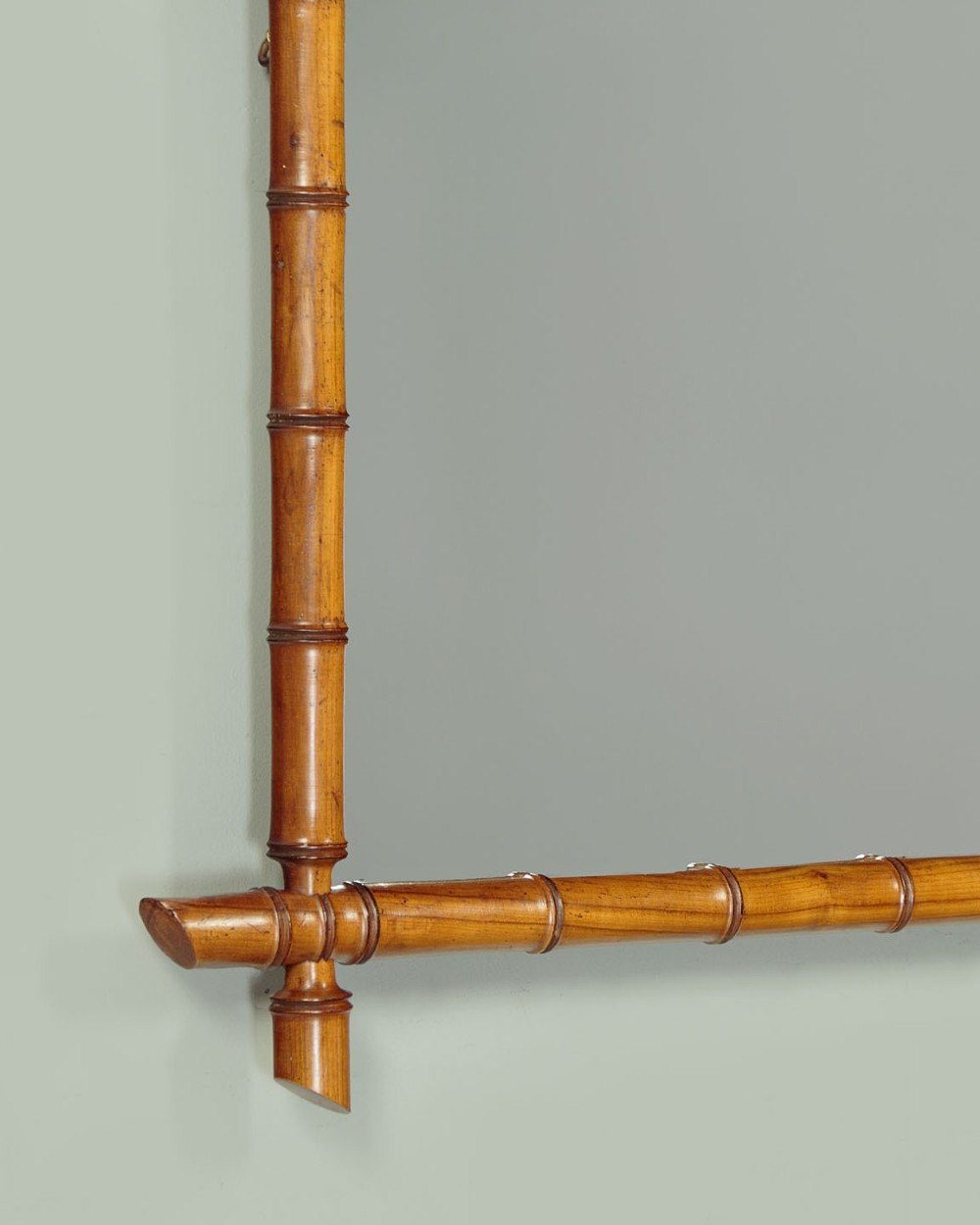 A late nineteenth-century rectangular wall mirror featuring a carved wooden frame that simulates natural bamboo with overlapping corner joints. View VI