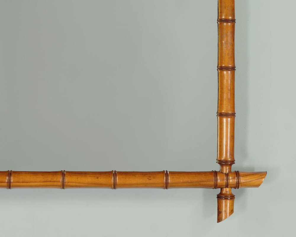 A late nineteenth-century rectangular wall mirror featuring a carved wooden frame that simulates natural bamboo with overlapping corner joints. View VII