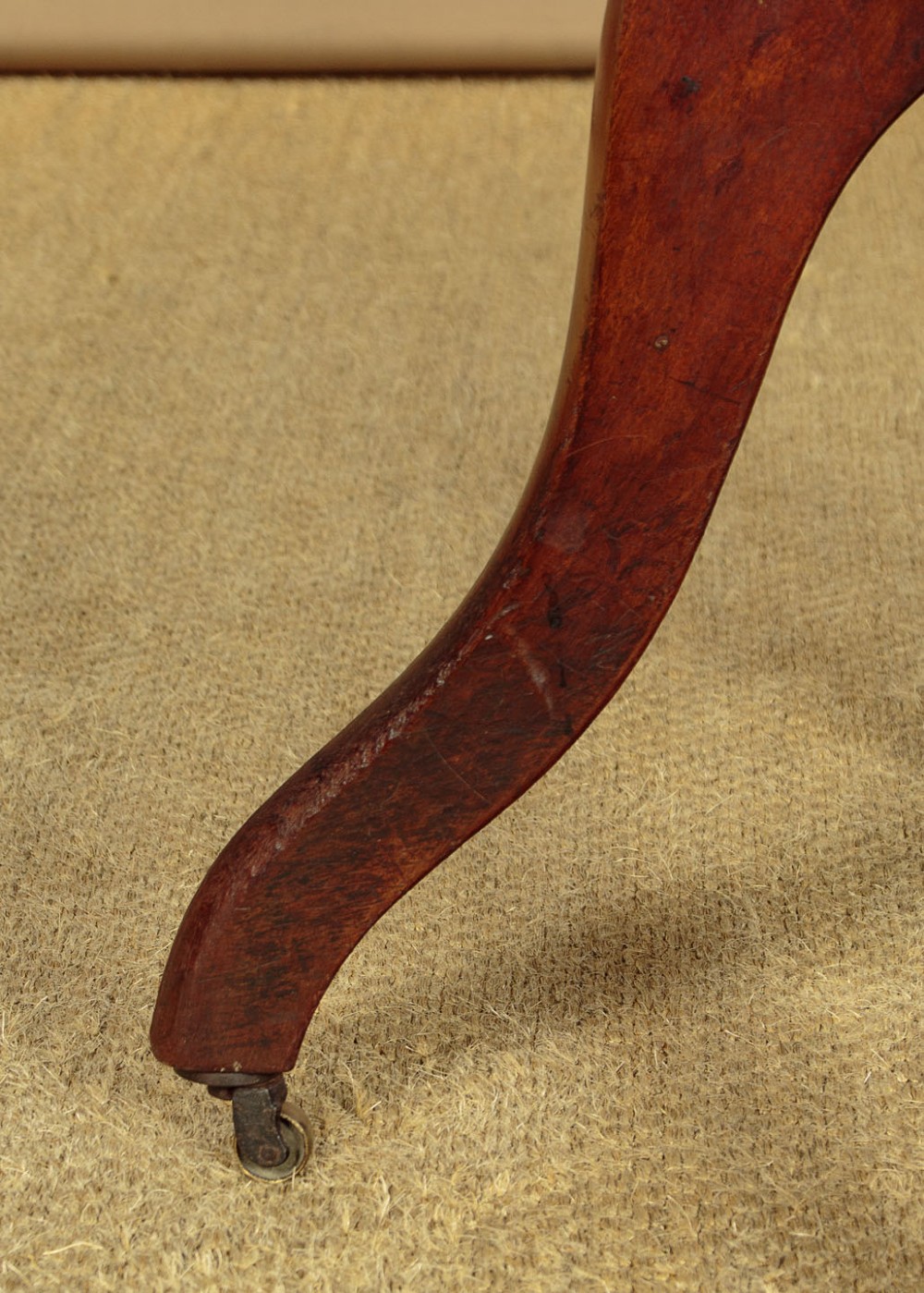 A late Victorian walnut revolving desk chair featuring turned spindles, a curved backrest, a shaped contoured seat, and splayed legs with brass castors. View IX