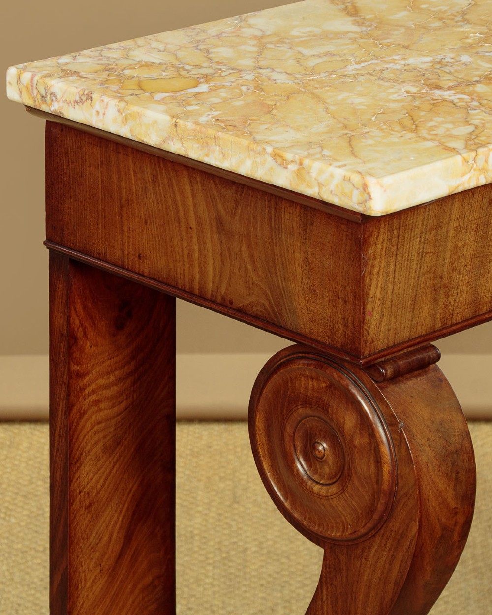 A late 19th-century mahogany console table featuring a light yellow marble top, S-scroll front supports with carved roundels, and a concave plinth base. View VI