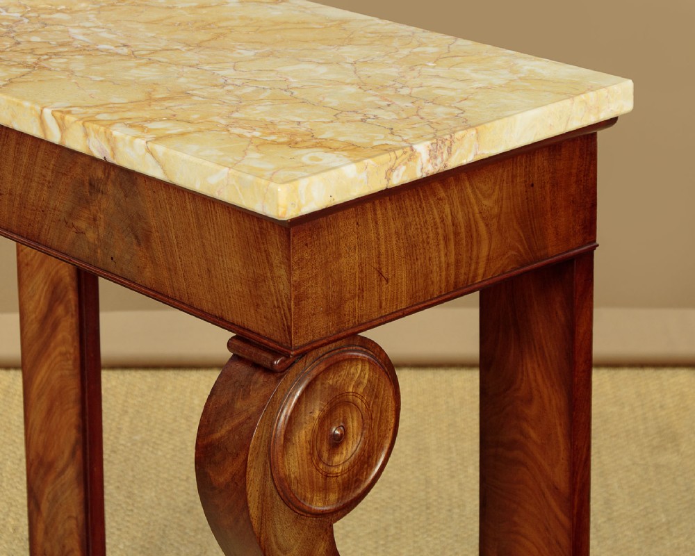 A late 19th-century mahogany console table featuring a light yellow marble top, S-scroll front supports with carved roundels, and a concave plinth base. View VII