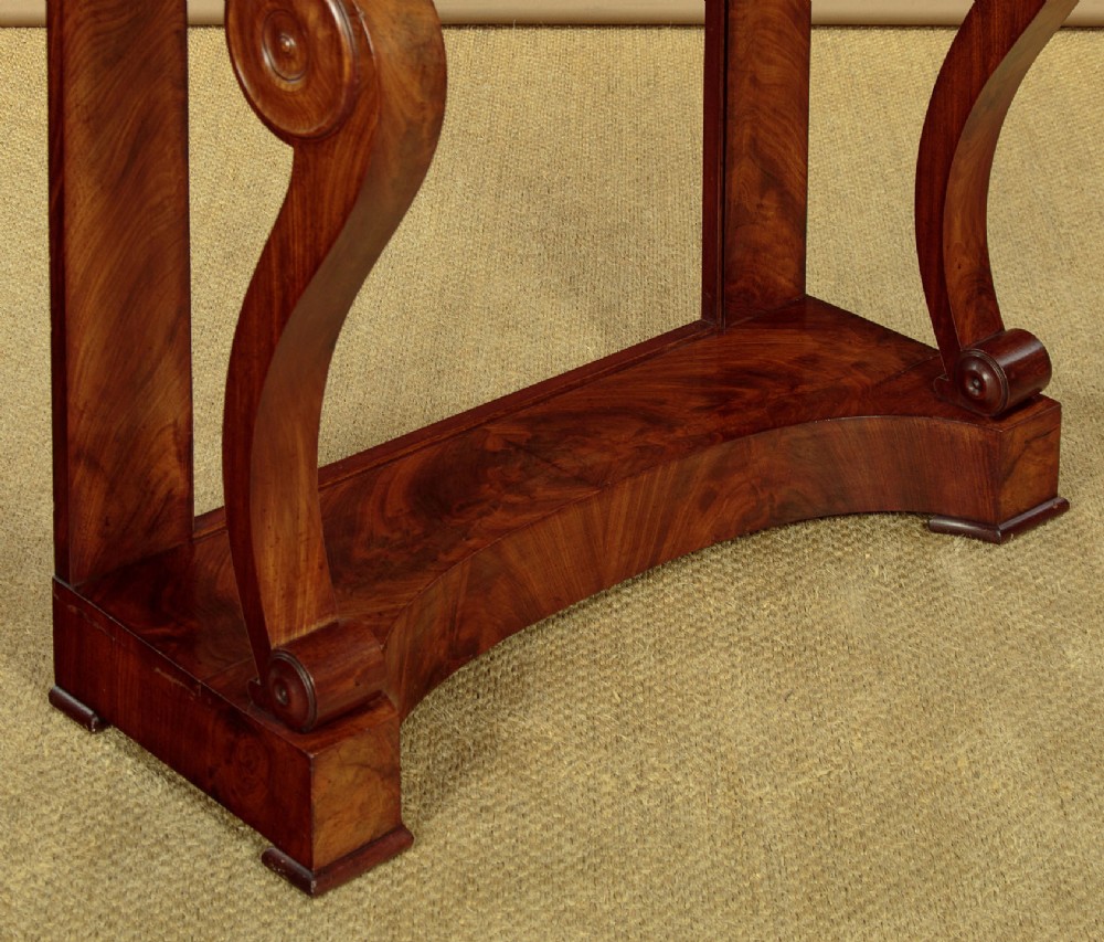 A late 19th-century mahogany console table featuring a light yellow marble top, S-scroll front supports with carved roundels, and a concave plinth base. View IX