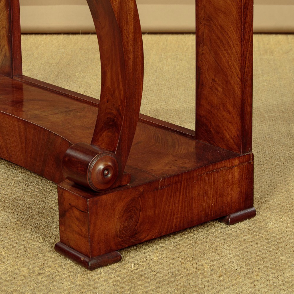 A late 19th-century mahogany console table featuring a light yellow marble top, S-scroll front supports with carved roundels, and a concave plinth base. View X