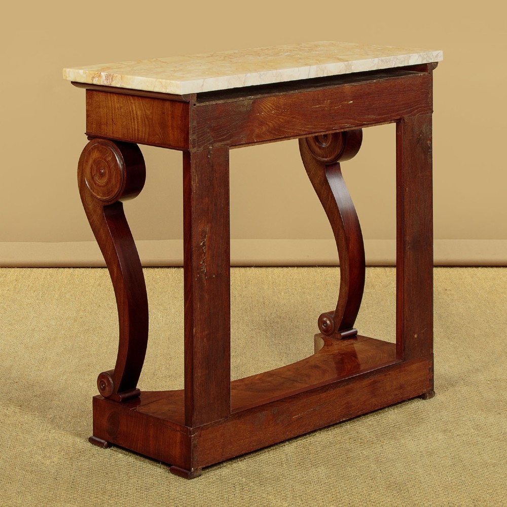 A late 19th-century mahogany console table featuring a light yellow marble top, S-scroll front supports with carved roundels, and a concave plinth base. View XI