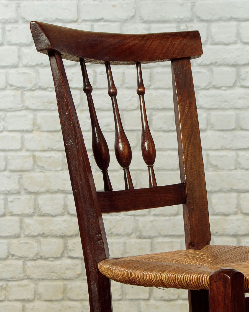 A set of four dark wood dining chairs featuring turned spindle backrests and hand-woven rush seats. View VI