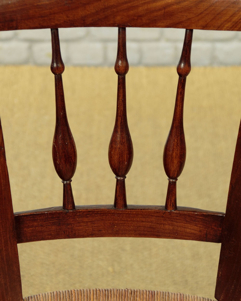 A set of four dark wood dining chairs featuring turned spindle backrests and hand-woven rush seats. View VII