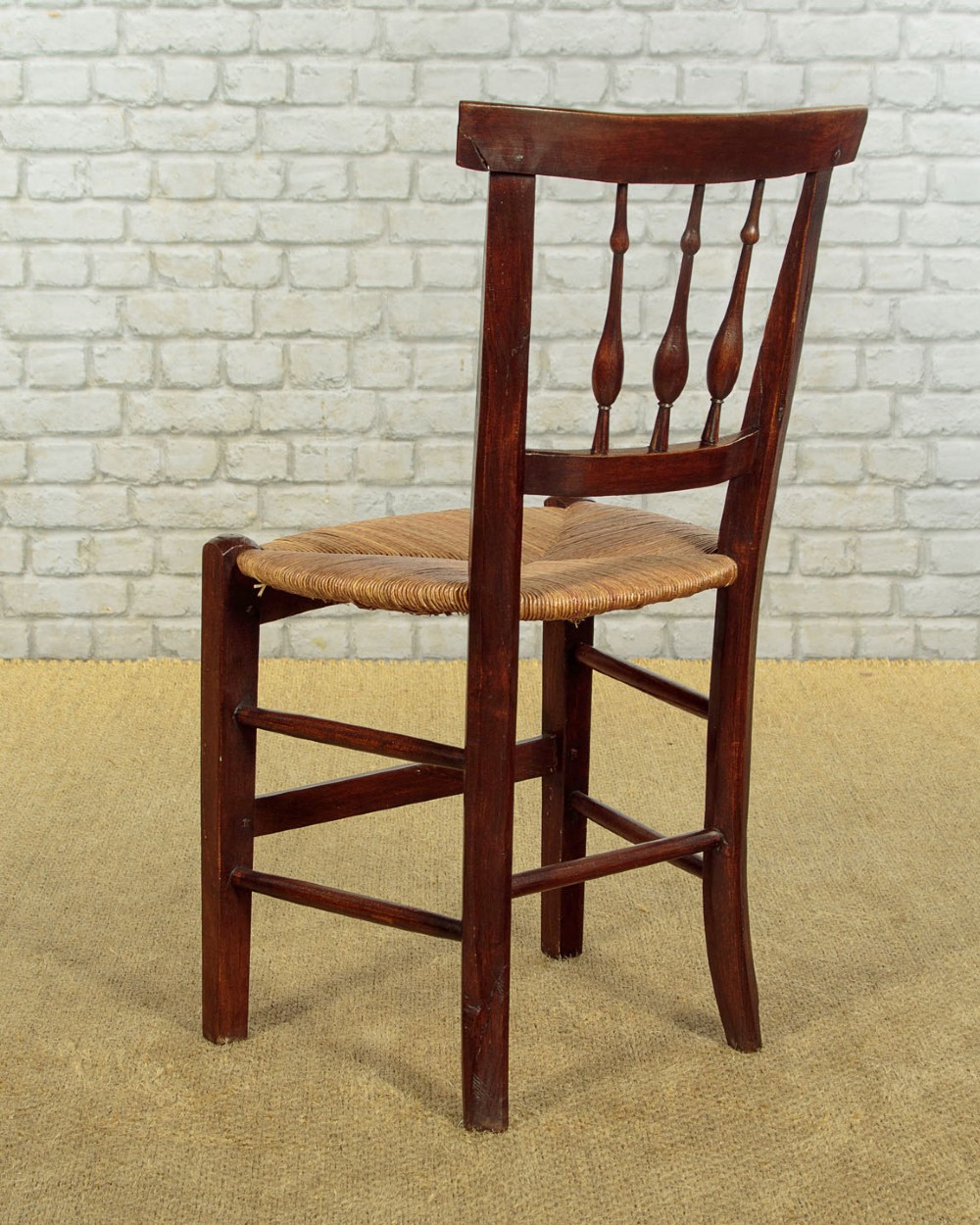 A set of four dark wood dining chairs featuring turned spindle backrests and hand-woven rush seats. View XI