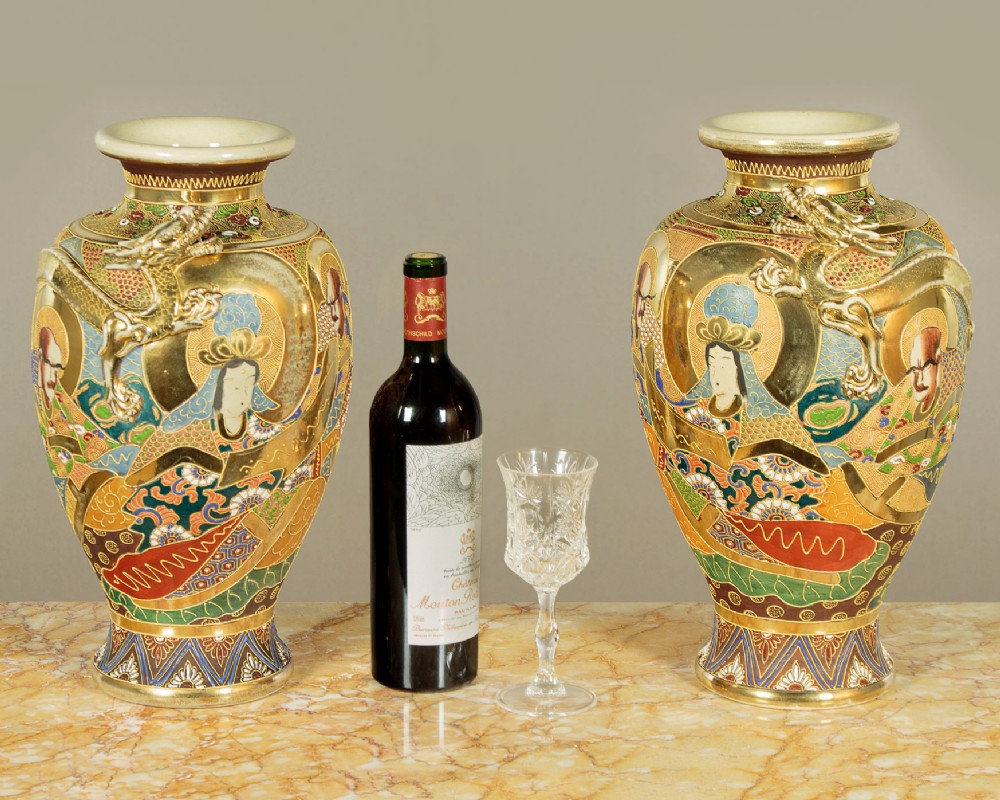 A pair of large Japanese Satsuma earthenware vases featuring hand-painted enamelled figures and high-relief gilded dragons wrapped around the necks. View II