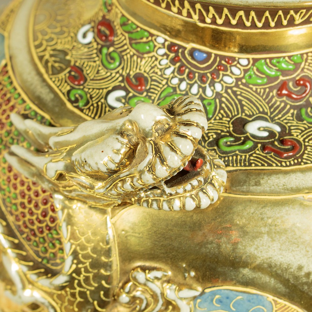 A pair of large Japanese Satsuma earthenware vases featuring hand-painted enamelled figures and high-relief gilded dragons wrapped around the necks. View V
