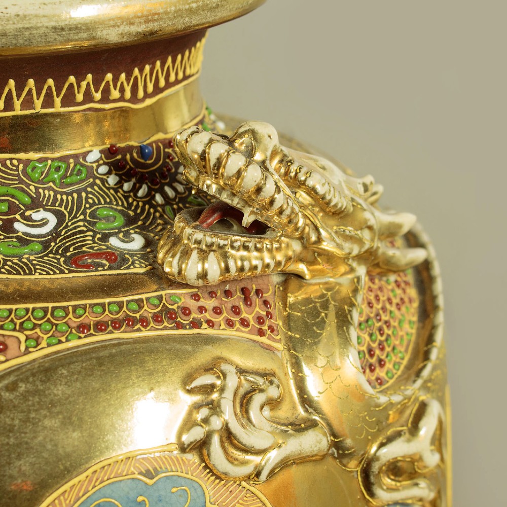 A pair of large Japanese Satsuma earthenware vases featuring hand-painted enamelled figures and high-relief gilded dragons wrapped around the necks. View VI